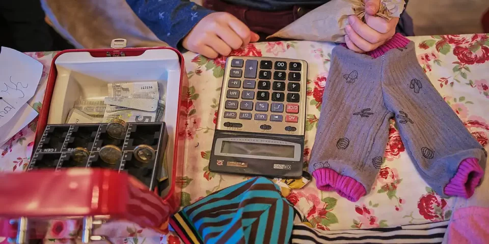Kasse mit Geld und Taschenrechner an einem Verkaufsstand.