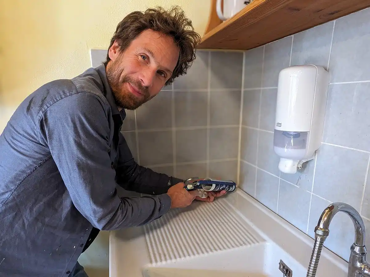 Eine Person repariert ein Waschbecken mit einer Kartuschenpresse.
