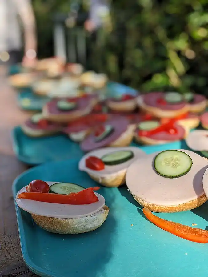 Belegte Brötchen mit Gurke und Gemüse liegen auf einem Tablett.