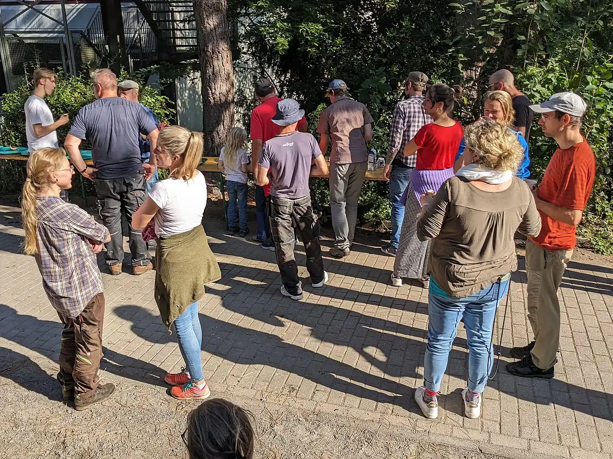Menschen stehen draußen zusammen und sprechen bei einem Treffen.