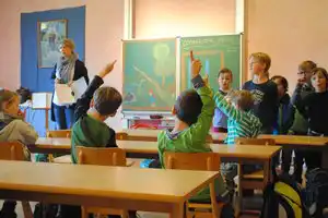 Kinder im Klassenraum melden sich im Unterricht.