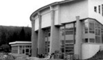 Großes rundes Schulgebäude mit hohen Fenstern, Außenansicht.