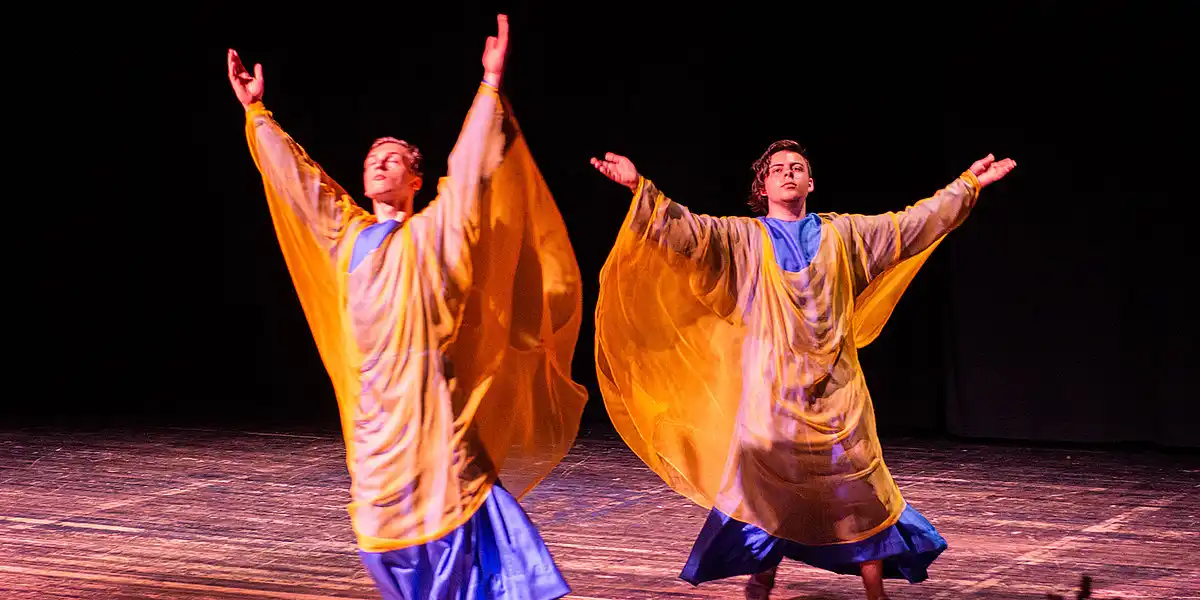 Schülerinnen und Schüler spielen ein Theaterstück auf einer Bühne.