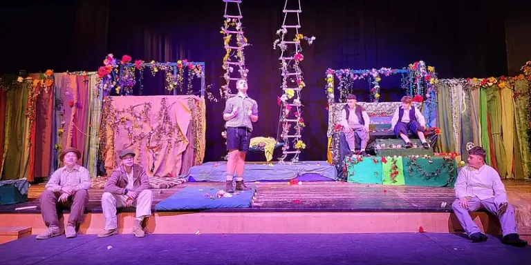 Schülerinnen und Schüler spielen ein Theaterstück auf einer Bühne.