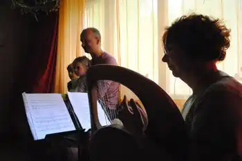 Musiker spielen gemeinsam mit Notenständern in einem Raum.