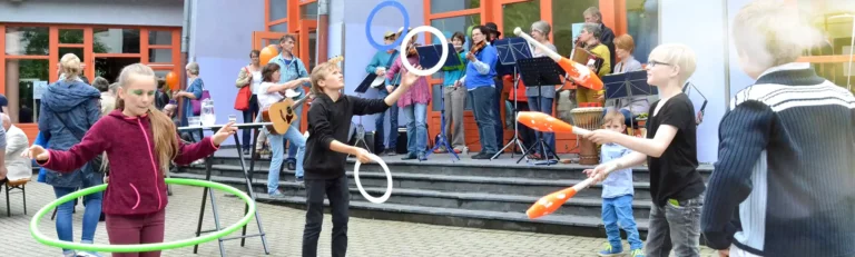 Kinder führen eine Zirkusaufführung auf einer Bühne auf.